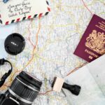 Map, camera and passport laid out on a table for trip planning