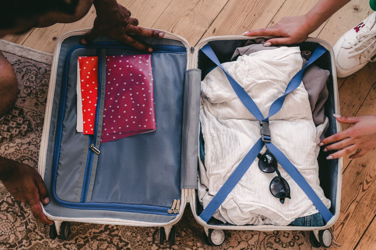 Clothes and sunglasses packed in an open suitcase